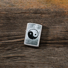 Lifestyle image of Yin Yang Design Street Chrome?äó Windproof Lighter laying on a wooden table. 