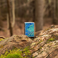 Lifestyle image of Realtree?« Blue and Green Camo Street Chrome?äó Windproof Lighter standing on a log in the woods.