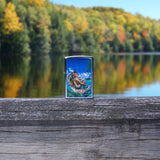 Lifestyle image of Rick Rietveld Mermaid Design Street Chrome™ Windproof Lighter standing on a railing outside, with trees and water in the background.