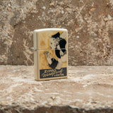 Lifestyle image of Zippo Windy Design Flat Sand Windproof Lighter standing on a countertop. 