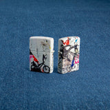Lifestyle image of two Zippo Pop Art Design 540 Color Windproof Lighter, one showing the back and the other showing the front of the design. Lighters are standing in a blue background.