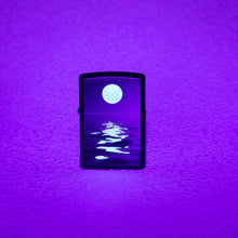 Lifestyle image of Full Moon?áDesign Black Light Black Matte Windproof Lighter showing the blacklight design.