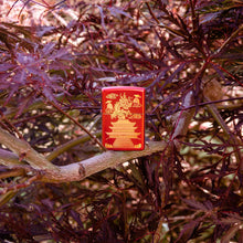 Lifestyle image of Eastern Design Dragon Design Metallic Red Windproof Lighter standing in a tree.