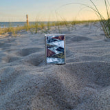 Lifestyle image of Patterns Design Street Chrome™ Windproof Lighter standing on a sandy beach.