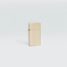 Lifestyle image of Slim® Flat Sand Windproof Lighter standing in a grey scene.