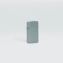 Lifestyle image of Slim?« Flat Grey Windproof Lighter standing in a grey background.