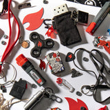 Lifestyle image of Zippo I Spy 540 Color Windproof Lighter, laying within a handful of Zippo themed items.